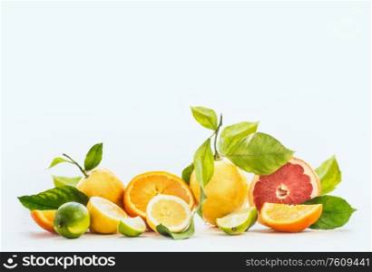 Group of various citrus fruits with juice splash at white background. Oranges, grapefruit, lime and lemon with green leaves. Slices, halves and quarters of fruits. Healthy food and drinks concept