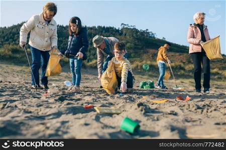 Group of volunteers picking up trash on the beach. Volunteers cleaning the beach