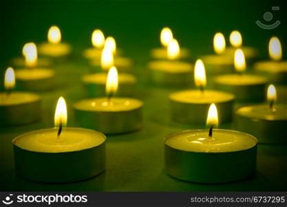 group of warm burning candles on the darkness