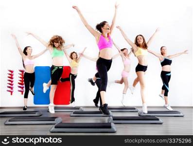 group of women doing aerobics on stepper in gym
