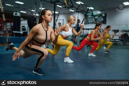 Group of women doing stretching exercise in sport club. People on fitness workout in gym, athletic girls in sportswear on training indoors. Women doing stretching exercise in sport club