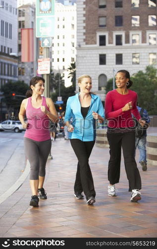 Group Of Women Power Walking On Urban Street