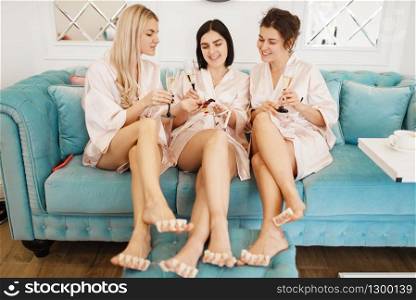 Group of women relax on pedicure procedure in beauty salon. Professional beautician and female customers, nail care in spa studio, toenail treatment. Group of women, pedicure in beauty salon