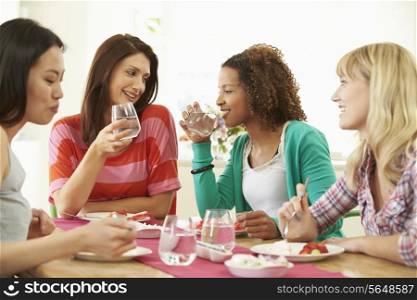 Group Of Women Sitting Around Table Eating Dessert