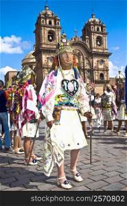 Group of women wearing traditional costumes and standing in front of a church, Peru