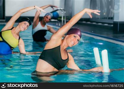 Group of Women with Female Instructor, Water Aerobics Class.. Aqua Fitness in Water Sport Centre.