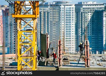 Group of workers at construction site on a top of a building