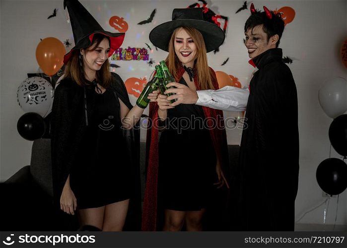 Group of young adult and teenager people celebrating a Halloween party carnival Festival in Halloween costumes drinking alcohol beer