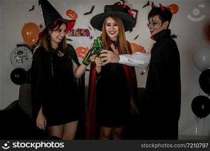 Group of young adult and teenager people celebrating a Halloween party carnival Festival in Halloween costumes drinking alcohol beer