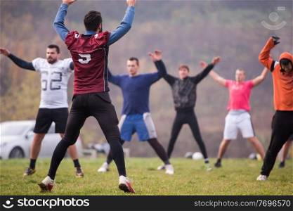 group of young american football players stretching and warming up together before a practice