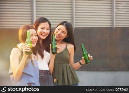 Group of young asian woman friends have happiness moment to celebrating dance party with bottle of beer in hand in nightclub.