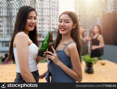Group of young asian woman friends have happiness moment to celebrating dance party with bottle of beer in hand in nightclub.