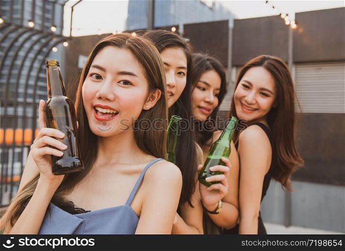 Group of young asian woman friends have happiness moment to celebrating dance party with bottle of beer in hand in nightclub.focused on girl in front blurred other.
