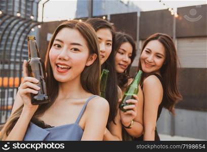 Group of young asian woman friends have happiness moment to celebrating dance party with bottle of beer in hand in nightclub.focused on girl in front blurred other.