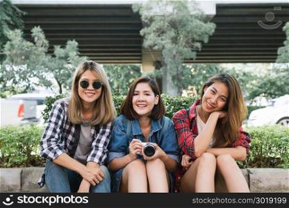 Group of young Asian women sitting along the street enjoying their city lifestyle in a morning of a weekend waiting for out door activity. Young women group and their city lifestyle. lifestyle concept