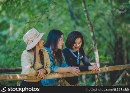 group of young asian women standing on bamboo bridge are looking beautiful nature while c&ing in forest with happiness together