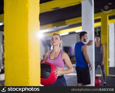 group of young athletes working out with medical ball at crossfitness gym. young athletes working out with medical ball