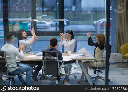 Group of young business people looking happy while celebrating success at their working places in startup office