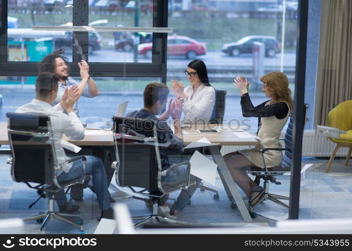 Group of young business people looking happy while celebrating success at their working places in startup office