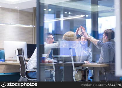 Group of young business people looking happy while celebrating success at their working places in startup office