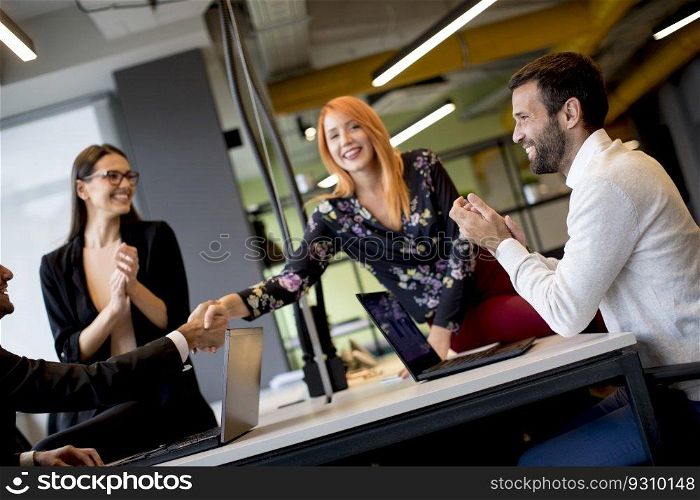 Group of young business people shaking hands in the office