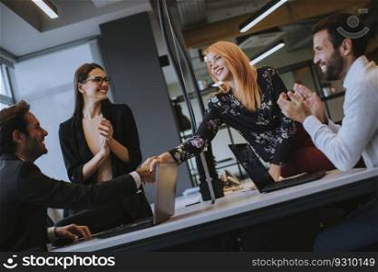 Group of young business people shaking hands in the office
