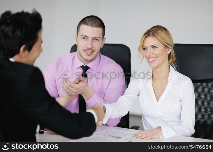 Group of young business people sitting in board room during meeting and discussing with paperwork