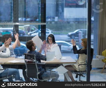 Group of young business people throwing documents and looking happy while celebrating success at their working places in startup office