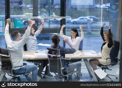 Group of young business people throwing documents and looking happy while celebrating success at their working places in startup office