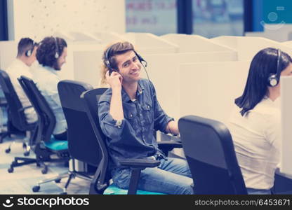 group of young business people with headset working and giving support to customers in a call center office