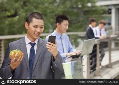 Group of young businessmen working outdoor and eating