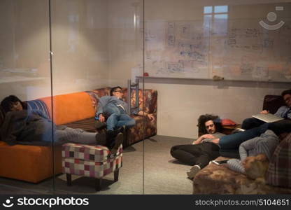 group of young casual software developer sleeping on sofa during a work break in creative startup office