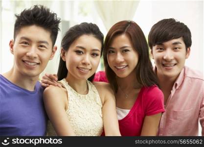 Group Of Young Chinese Friends Relaxing On Sofa At Home