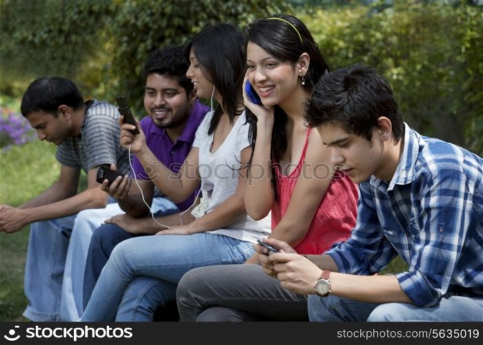 Group of young friends busy with their mobile phones