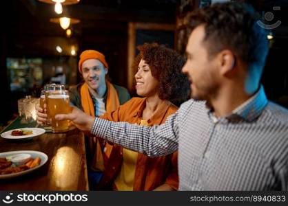 Group of young friends celebrating success, sharing emotions while rest at sports bar. Millennial diverse people drinking beer and toasting for victory. Group of young friends celebrating success while rest at sports bar