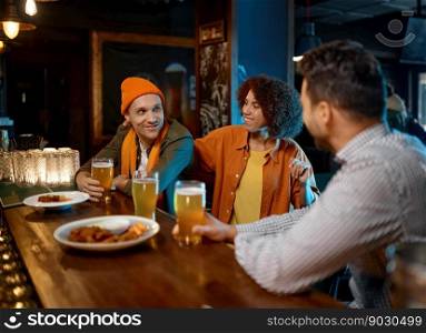 Group of young friends celebrating success, sharing emotions while rest at sports bar. Millennial diverse people drinking beer and toasting for victory. Group of young friends celebrating success while rest at sports bar