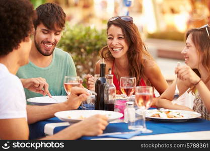 Group Of Young Friends Enjoying Meal In Outdoor Restaurant