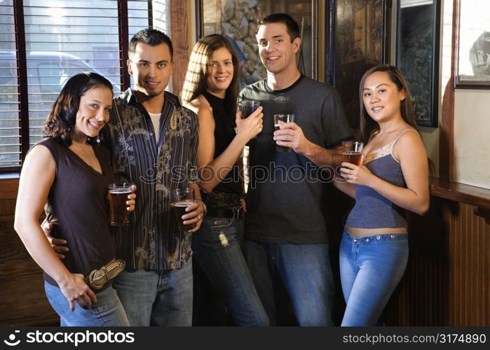 Group of young friends hanging out in pub and drinking beer.