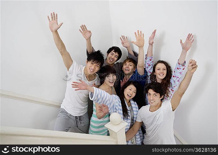 Group of young friends raising arms