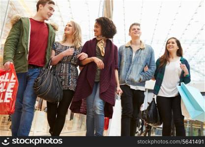Group Of Young Friends Shopping In Mall Together