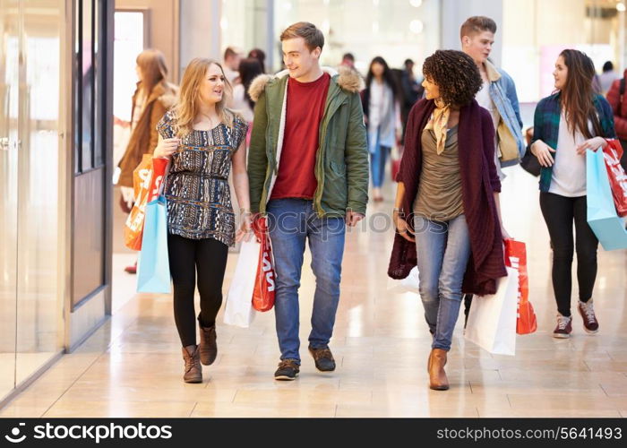 Group Of Young Friends Shopping In Mall Together