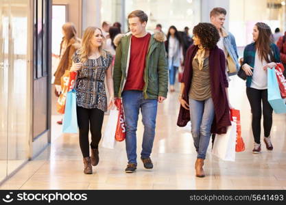 Group Of Young Friends Shopping In Mall Together