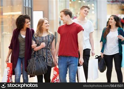 Group Of Young Friends Shopping In Mall Together