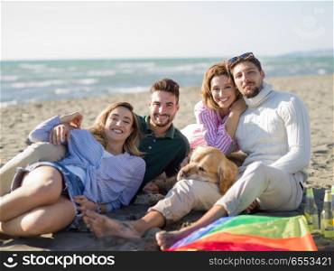 Group Of Young Friends Spending The Day On A Beach during autumn day. Group of friends having fun on beach during autumn day