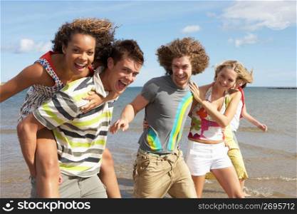 Group Of Young Friends Walking Along Summer Shoreline