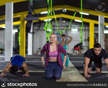 group of young healthy people doing pushups at crossfitness gym. young healthy people doing pushups