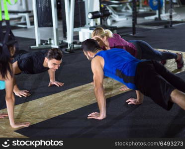 group of young healthy people doing pushups at crossfitness gym. young healthy people doing pushups