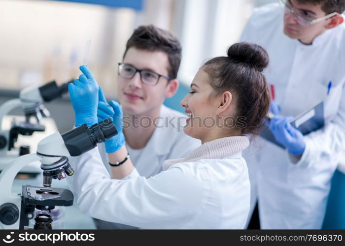 Group of young medical students doing research together in chemistry laboratory,teamwork by college student indoors