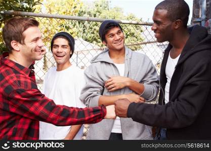 Group Of Young Men Greeting One Another In Urban Setting