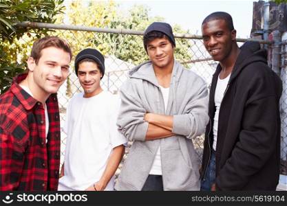 Group Of Young Men In Urban Setting Standing By Fence